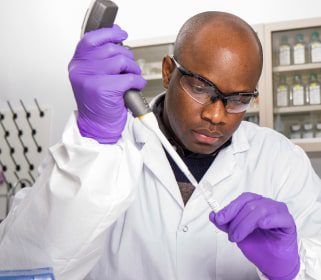 Miespuolinen Charles Riverin tutkija, joka työskentelee pipetin ja laboratorionäytteiden kanssa